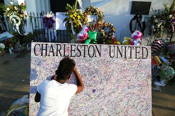 2. Charleston kentindeki Emanuel African Methodist Episcopal Kilisesi'nde 9 kişinin öldürüldüğü saldırının ardından, 10 yaşındaki Jennice Barr kilisenin önündeki tahtaya notunu yazıyor.