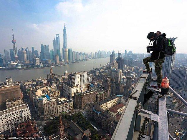 7. Shangai limanı ve gökdelen sırasınının fotoğraflarını çekmek için reklam panolarına tırmandılar.