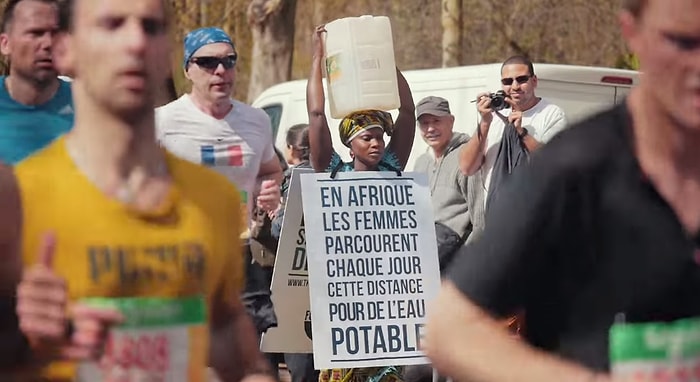 Maraton Koşucularına Kafasında Taşıdığı Su Şişesiyle Eşlik Eden Kadın