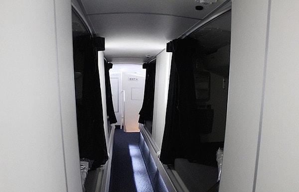 Koridor boyunca bölmeli yataklar bulunan bu uçak Amerikan Hava Yolları Boeing 773 uçağı. Fakat koridor o kadar alçak ki emekleyerek geçmeniz gerekiyor.