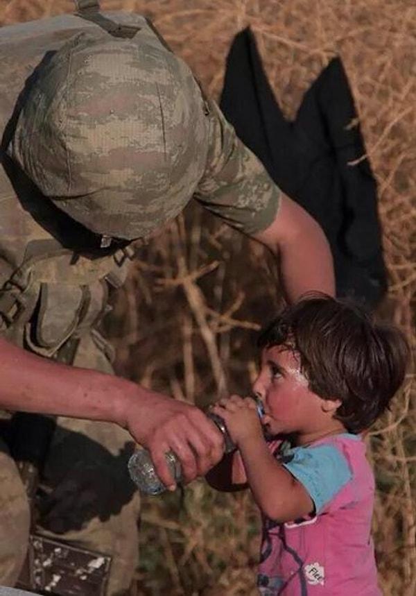 9. Şefkatin nasıl bir şey olduğunu unutmak üzere olduğu gözlerinden okunan bir çocuğa yardımı dokunan askerimiz.