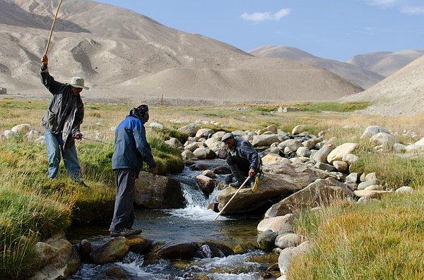 10. Badahşan, Tacikistan'da balık tutan bu üç adama rastlayan Gandy; onların önce sopalarla suyu dövdüğünü, bu şekilde balıkları saklandıkları yerden çıkardıktan sonra bir ağla yakaladıklarını görmüş.