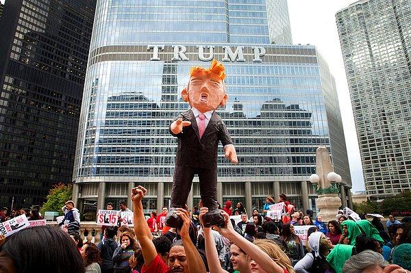 2. Chicago, Illinois'deki Trump Tower'ın önünde toplanan protestocular, Amerikan başkanlık adayını temsil eden bir pinyata ile.