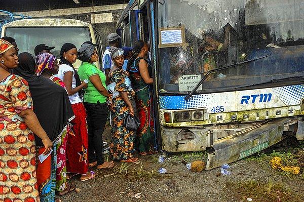 3. Konakri, Gine'de seçmenler, seçim kabinine dönüştürülmüş eski bir otobüsün önünde başkanlık seçimleri için beklerken.