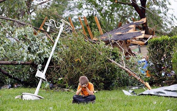 8. Evlerini yıkıp geçen hortumun ardından, Teksas'lı bir çocuk evlerinin bahçesinde otururken. (11 Mayıs)
