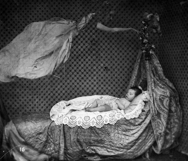 7. Beşikte uyumakta olan bir bebeğin üzerinde görülen figür, 1860 civarı.