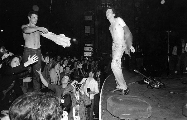19. The Clash grubunun solisti Joe Strummer konser sırasında tişörtünü bir hayranı ile değiştiriyor. (Mayıs 1977)