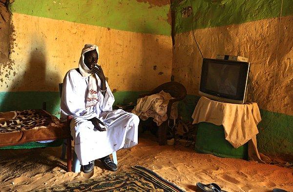 1. Sudan'ın Kuzey Darfur Eyaletinde, televizyonuyla görüntülenen bir adam.