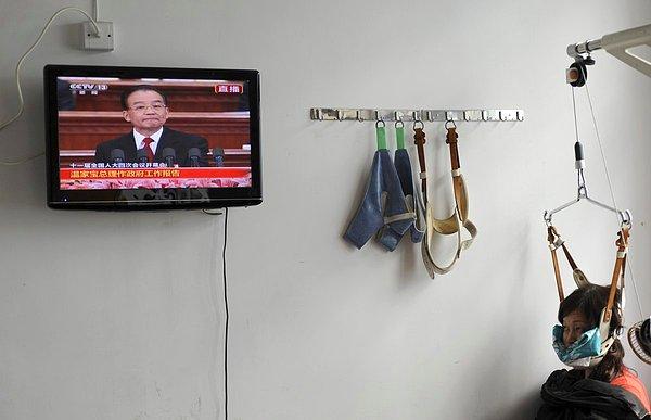 12. Çin'in Jiaxing kentindeki bir hastanede, tedavi olurken televizyon izleyen bir kadın.