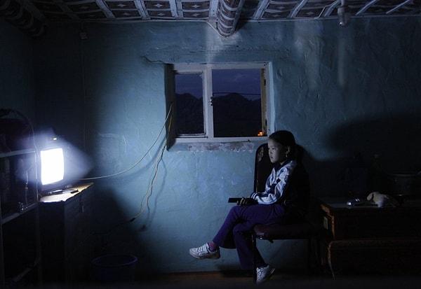 20. Moğolistan'ın Bulgan ilinde televizyon izleyen genç bir kadın.