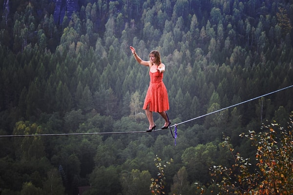 В платье и туфлях-стилетах она идет по канату так, ....