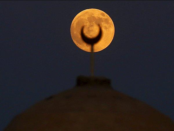 14. Kahire, Mısır'daki Al Fayoum Governorate çölünde yer alan bir caminin minaresi üzerinde yükselen 'Kanlı Ay', 27 Eylül 2015.