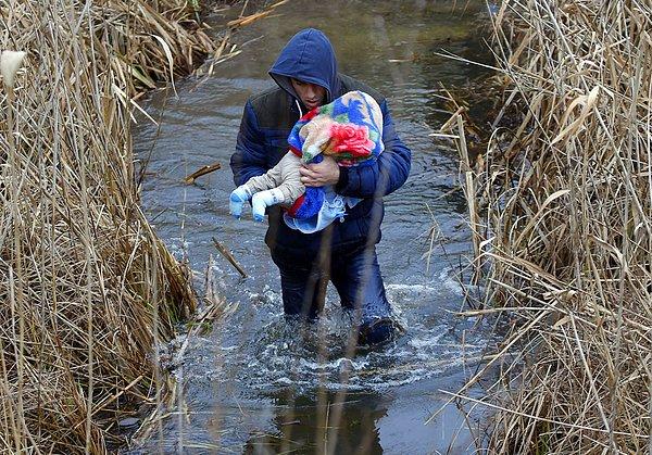 13. 6 Şubat 2015'te, bebeğiyle birlikte Macaristan-Sırbistan sınırını aşmaya çalışan Kosovalı adam.