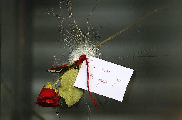 30. Paris'te bir restoranın penceresindeki kurşun deliğine yerleştirilen ve üzerindeki kağıtta "Ne adına?" yazan gül. 15 Kasım 2015.