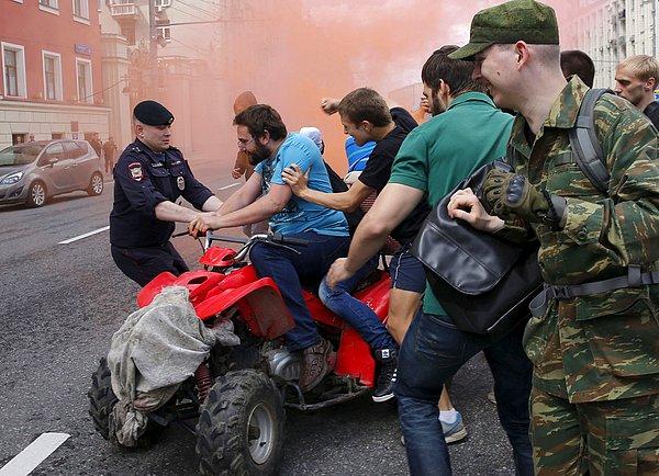 32. Moskova'da LGBT yürüyüşü sırasında, eşcinsel karşıtı protestocuların saldırdığı aktivist, polis tarafından tutuklanıyor.