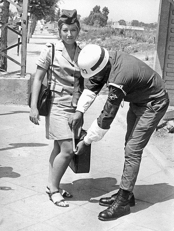 28. İsrail askeri polisi, meslektaşı olan kadın askerin yönetmelikte belirtilen etek uzunluk ölçüsüne uyup uymadığını kontrol ediyor, 1969.