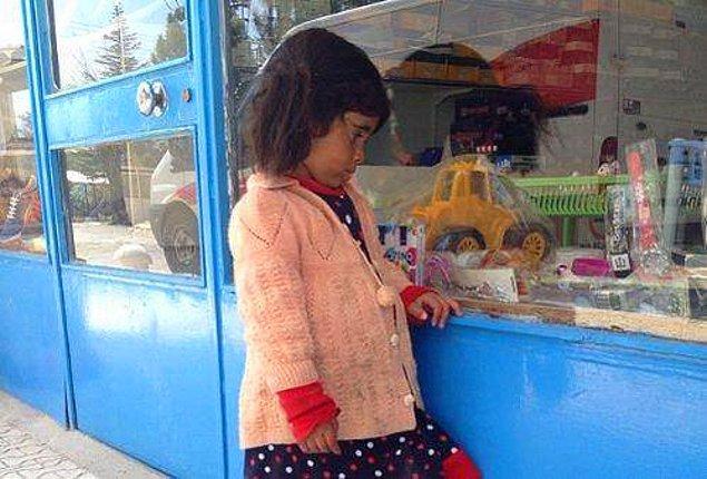 2. Vitrindeki oyuncaklara gözü takılmış küçük bir kız.