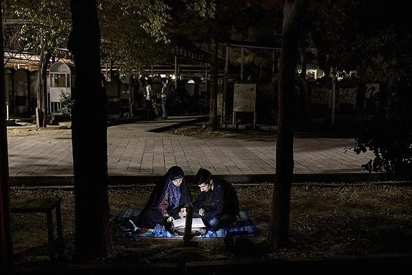 11. İki kişi parkta Kuran okuyor.