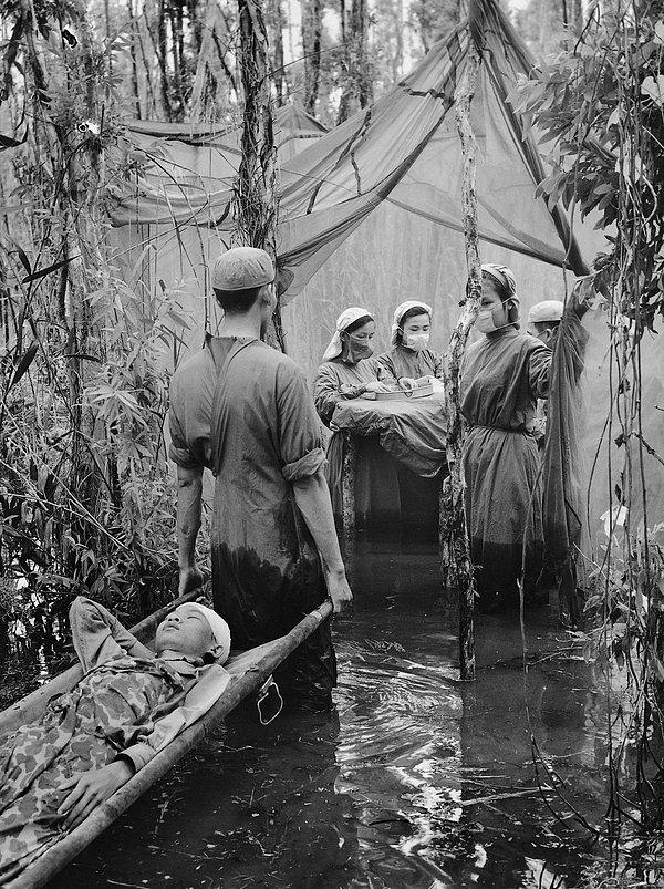 15. Kamboçyalı gerilla Danh Son Huol, bir bataklığın üzerine kurulan geçici ameliyathaneye götürülürken. (1970)
