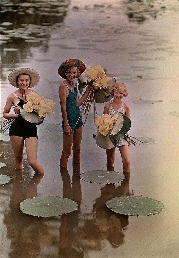 35. Ellerindeki Amerikan lotuslarıyla suyun içinde duran kızlar. Amana, Iowa. Kasım, 1938.