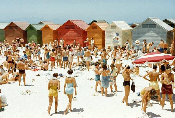 4. Cape Town'daki sahil kulübeleriyle dolu bir plajda güneşin tadını çıkaran Güney Afrikalılar. Ağustos, 1953.