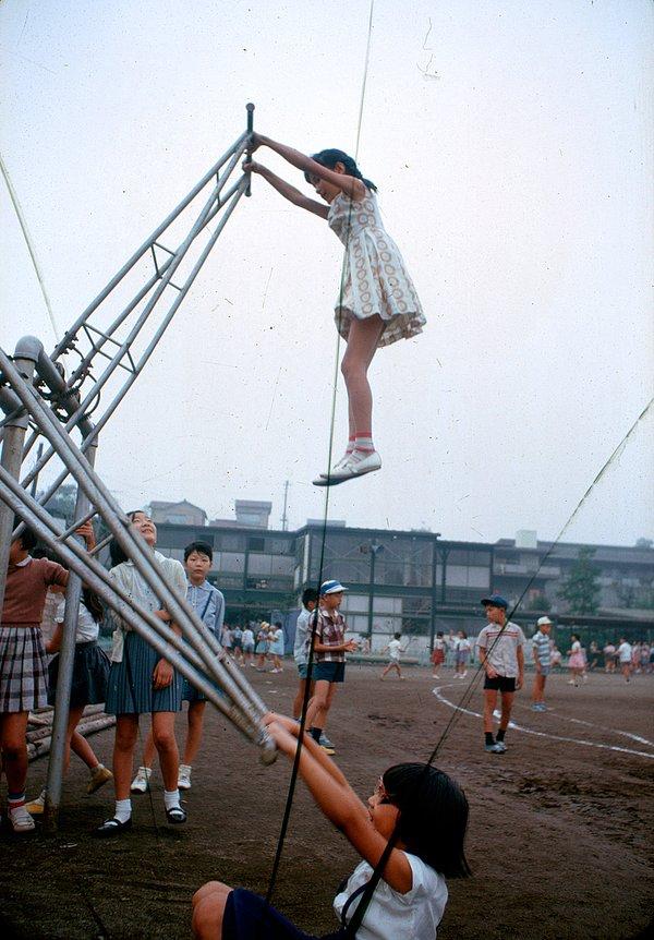 18. Küçük bir kız, ayakta durulan bir çeşit tahterevallide boyunun iki katı yüksekliğe çıkmışken. Tokyo, Japonya. Kasım, 1964.