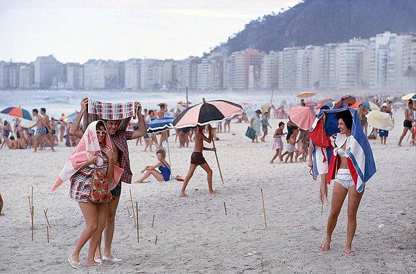 26. Rio de Janeiro'daki bir plajda yaz yağmurundan korunmaya çalışan insanlar. Eylül, 1962.