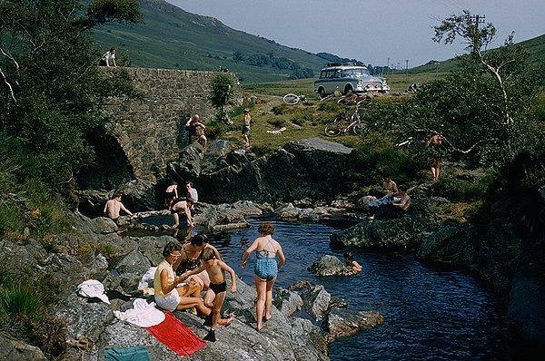 38. Kemerli bir taş köprünün yakınlarında suyun tadını çıkaran tatilciler. Arran Adası, İskoçya. Temmuz, 1965.