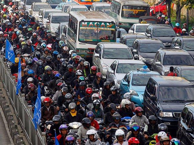 10. Endonezya'nın Jakarta şehrinde yolcular; otobüs, araba ve motosikletlerle saatlerce trafikte kalıyorlar.