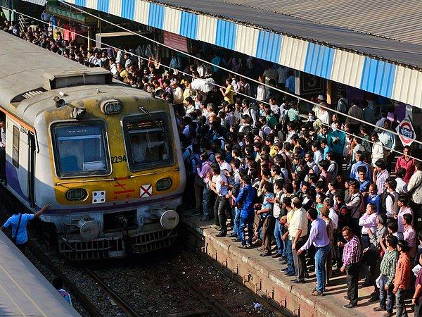 16. Hindistan'ın Bombay şehrinde çekilen bu fotoğrafta; yolcular, bir tren istasyonunda treni yakalamaya çalışıyorlar.