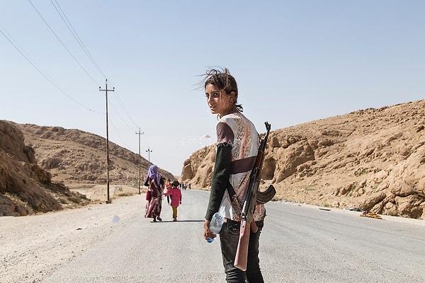 2. Ailesini IŞİD'den korumak için saldırı tüfeği taşıyan bir Yezidi kadını.