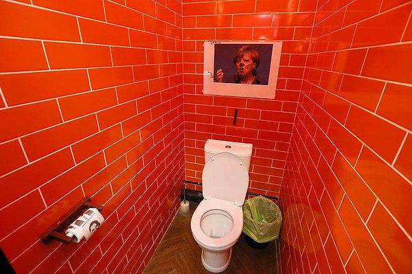 Angela Merkel'in fotoğrafı ise tuvalette, üstü karalanmış halde karşımıza çıkıyor.