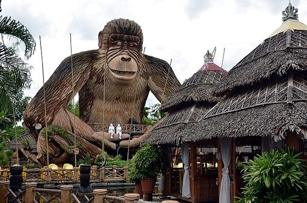 15. Эта гигантская обезьяна наблюдает за двумя скульптурами белых людей и деревней