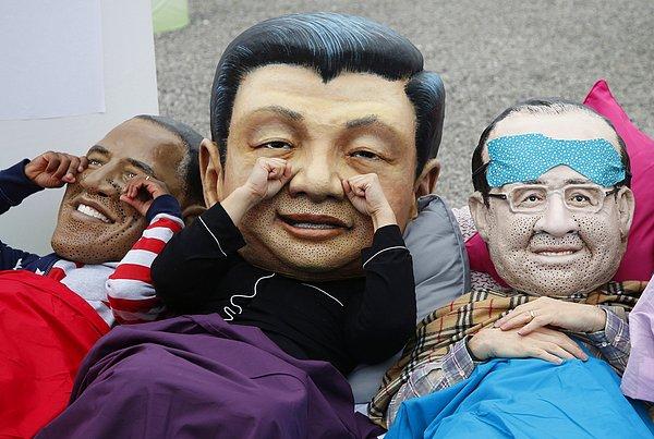 13. Yardım kuruluşu Oxfam üyeleri, İklim Değişikliği Zirvesi'nin yapıldığı salonun dışında ABD Başkanı Barack Obama, Fransa Cumhurbaşkanı François Hollande ve Çin Devlet Başkanı Xi Jinping maskeleri ile poz veriyor. Paris, Fransa. 10 Aralık 2015.