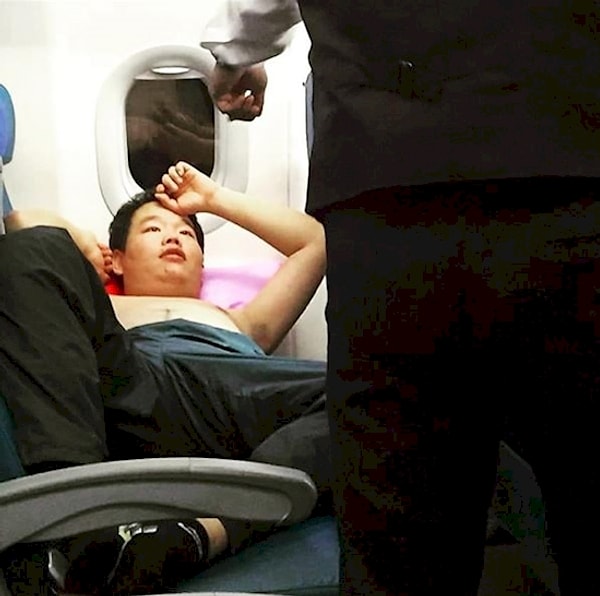 2. Это лицо победителя, знакомьтесь. Лицо человека, который прекрасно знает, что эта железная птица находится высоко в небе и приземлится еще только через 10 часов. А пока он может безнаказанно оставаться с голым торсом и лежать, развалившись на два сиденья.