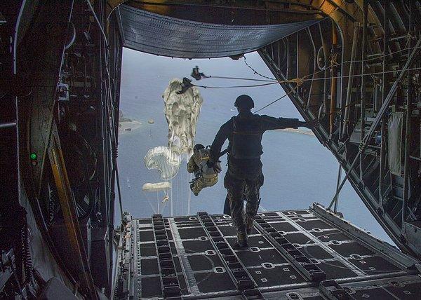 ABD Deniz Kuvvetleri askerleri C-130 Hercules uçağı üzerinde bordaya bağlı paraşütle atlıyorlar.