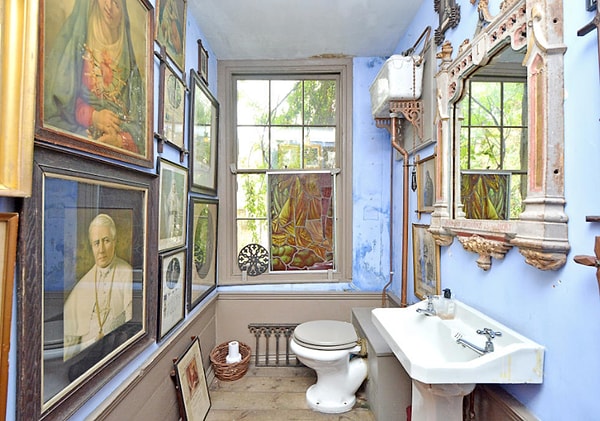 13. Ванная комната на первом этаже буквально забита старинными картинами, а над умывальником висит зеркало в георгианском стиле