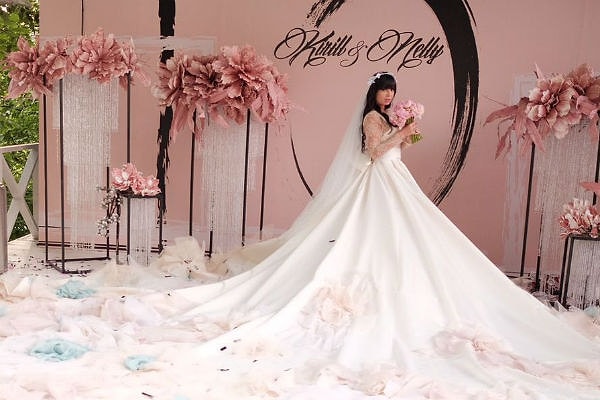 2. Платье невесты было поистине красивым и очень необычным: белое платье с длинным шлейфом и голубыми вставками смотрелось на Нелли идеально, а распущенные волосы, прикрытые фатой, дополняли воздушный образ настоящей принцессы. Еще больше нежности добавили невесте розовые пионы, которые она выбрала для букета