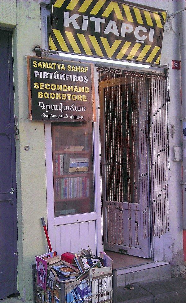 Kitapçının kapısında beş dilde "Kitapçı" yazıyor.
