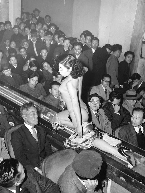 22. Tokyo striptiz şovunda ışıklı bir geçit üzerinde performansını sergileyen bir striptizci, 1957.