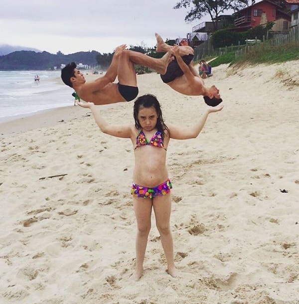 13. Девочка, "держащая" на руках двух бразильских гимнастов