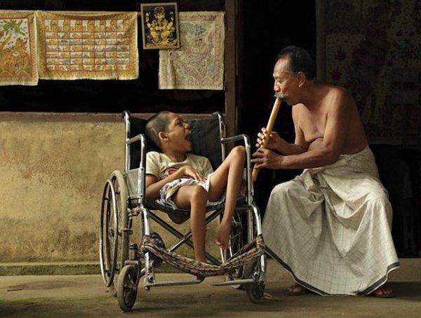 4. Bali'de bir adam, çocuğa müzik çalarken