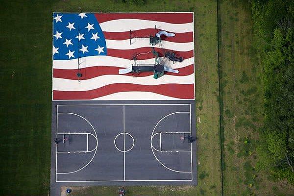 14. Amerikan bayraklı bir oyun parkı ve yanındaki basketbol kortu. Stow, Massachussetts.