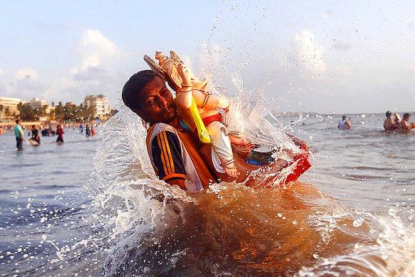 11. Hindistan'da düzenlenen Ganesh Chaturthi Festivali'nin ikinci gününde Umman Denizi'nde dindar bir adam bereket tanrıçası olarak bilinen Ganesh'in putunu taşıyor.