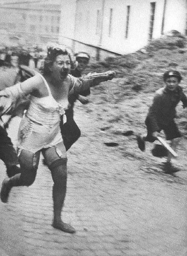 6. Lviv Katliamı sırasında erkekler ve çocuklar tarafından kovalanan Yahudi bir kadın, Temmuz, 1941.