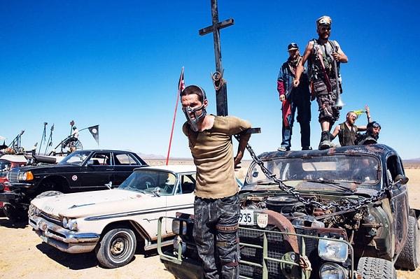 Sürüş öncesi Nux'un arabasına zincirlenen Mad Max kostümlü genç