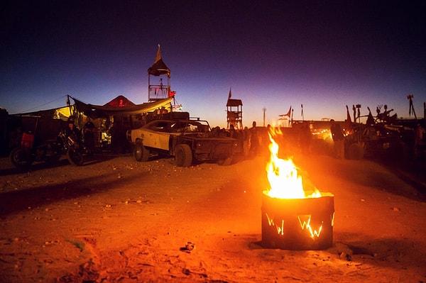 Çölün sıcaklığı birden düştüğü için, katılımcılar akşamları paslanmış konteynırlarda yakılan ateşin kenarında dans edip, vakit geçirerek ısınmaya çalışıyorlar.