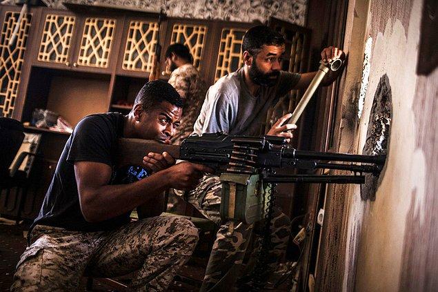 12. Tripoli hükümetine bağlı Libya güçlerinden bir asker nişancı tüfeği için uygun pozisyon ararken.