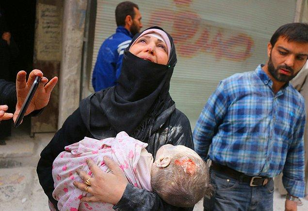 14. Al-Muasalat bölgesine yapılan hava saldırısından sonra, bina enkazından çıkarılan çocuğunun cesedini taşıyan Suriyeli kadın.