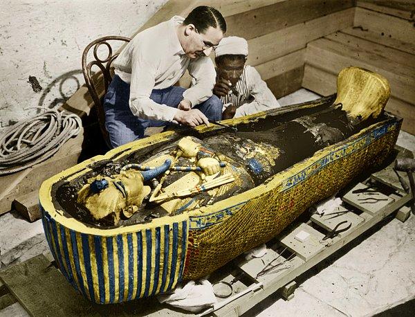 20. Arkeolog Howard Carter, 1923 yılında mezarı açılan Tutankhamun'un altından lahitini incelerken.